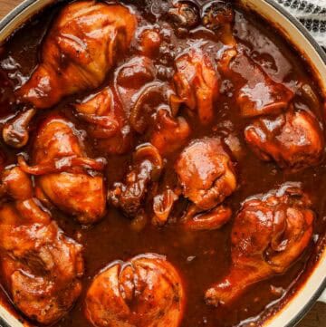 Oven baked bbq chicken drumsticks with mashed potatoes and asparagus on wooden board