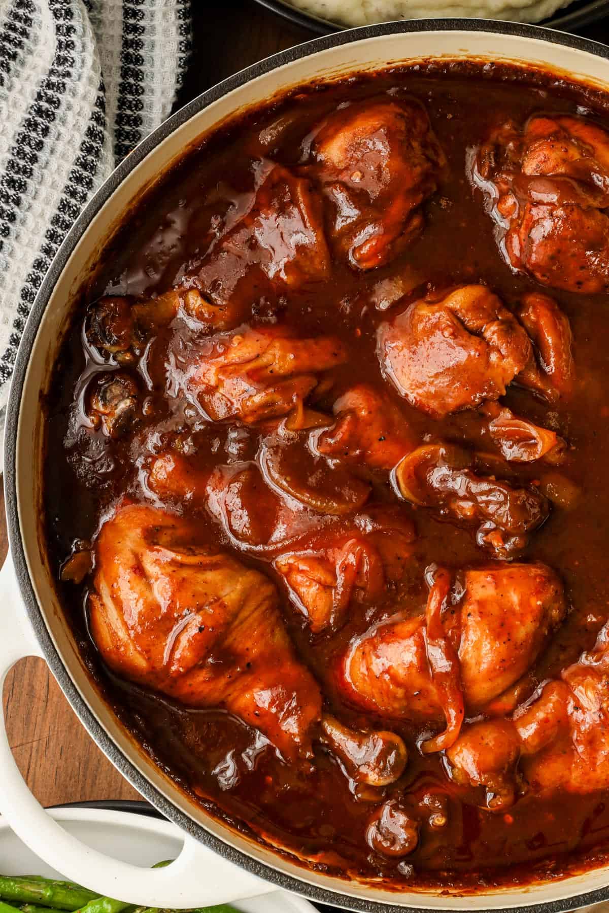 half picture of Oven baked bbq chicken drumsticks on wooden board