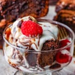 Chocolate Fudge Brownies in glass cup with raspberries on the side and on top Pinterest Pin