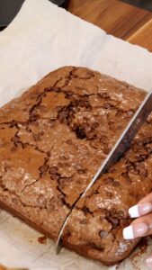 Cutting baked brownies on parchment paper