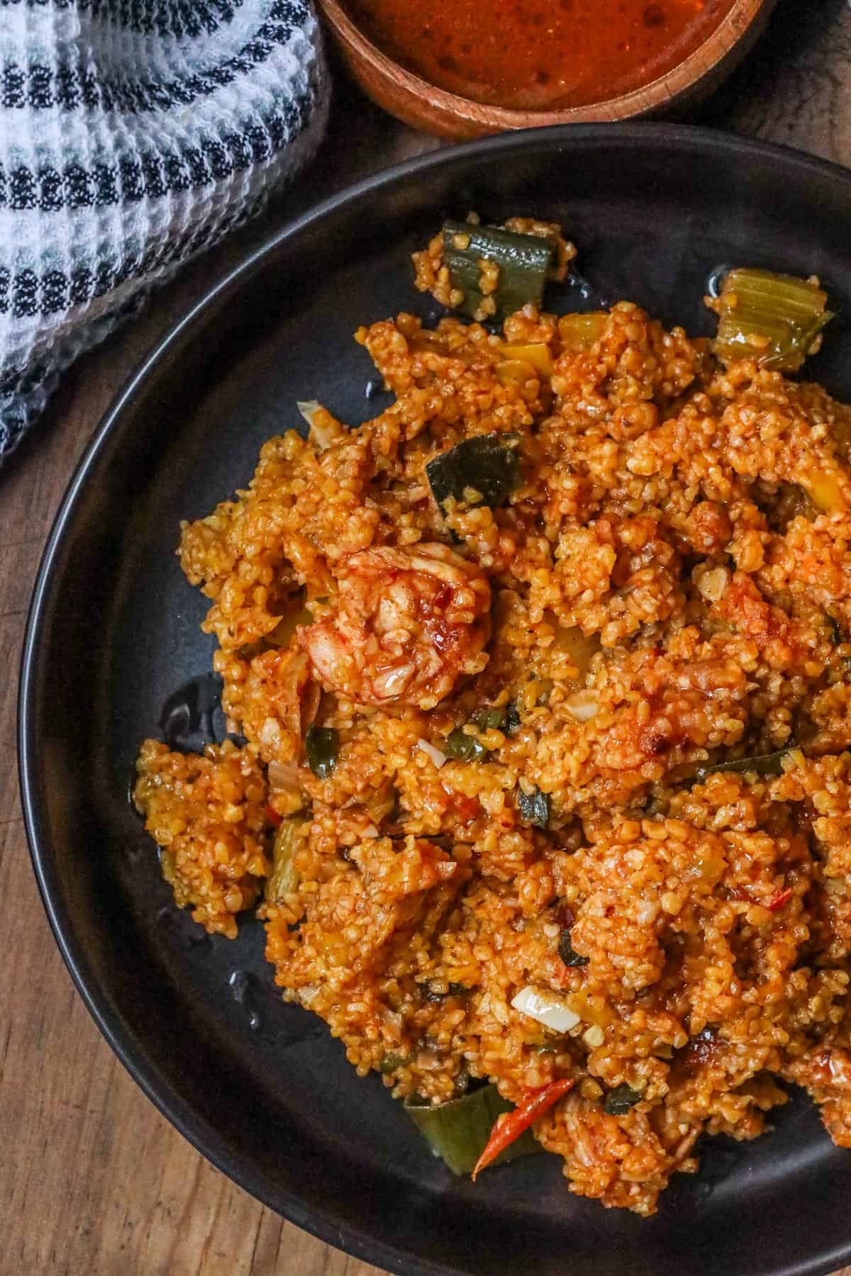 Mayi moulin with shrimp in black bowl and sauce on the side