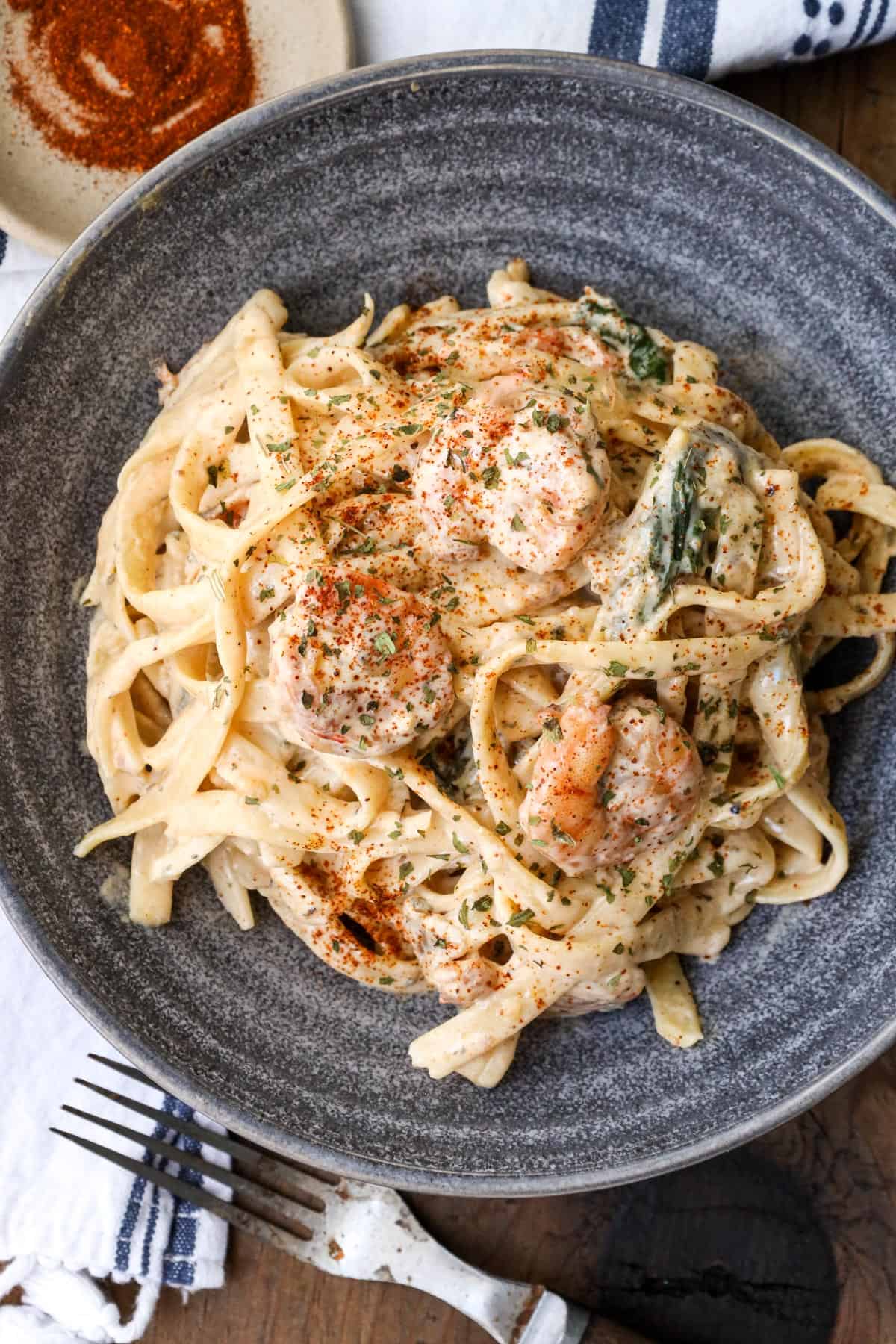 shrimp Alfredo With Spinach in gray bowl