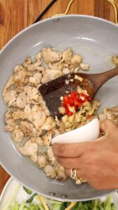 cooking chicken and adding ginger and pepper