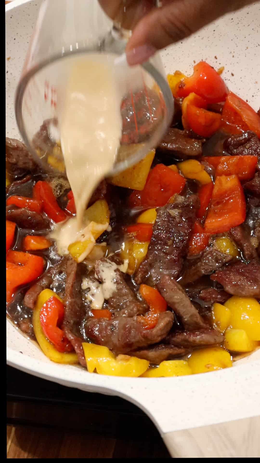 adding slurry to the beef and peppers mixture