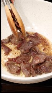 Removing the meat with wooden tongs