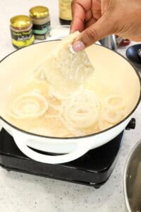 adding salted fish and to onions and oil
