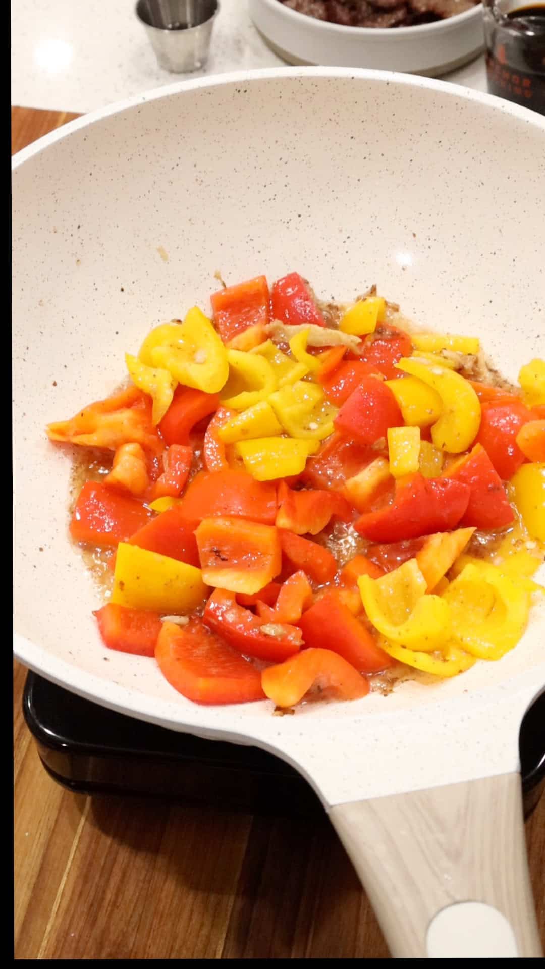 adding bell peppers to wok