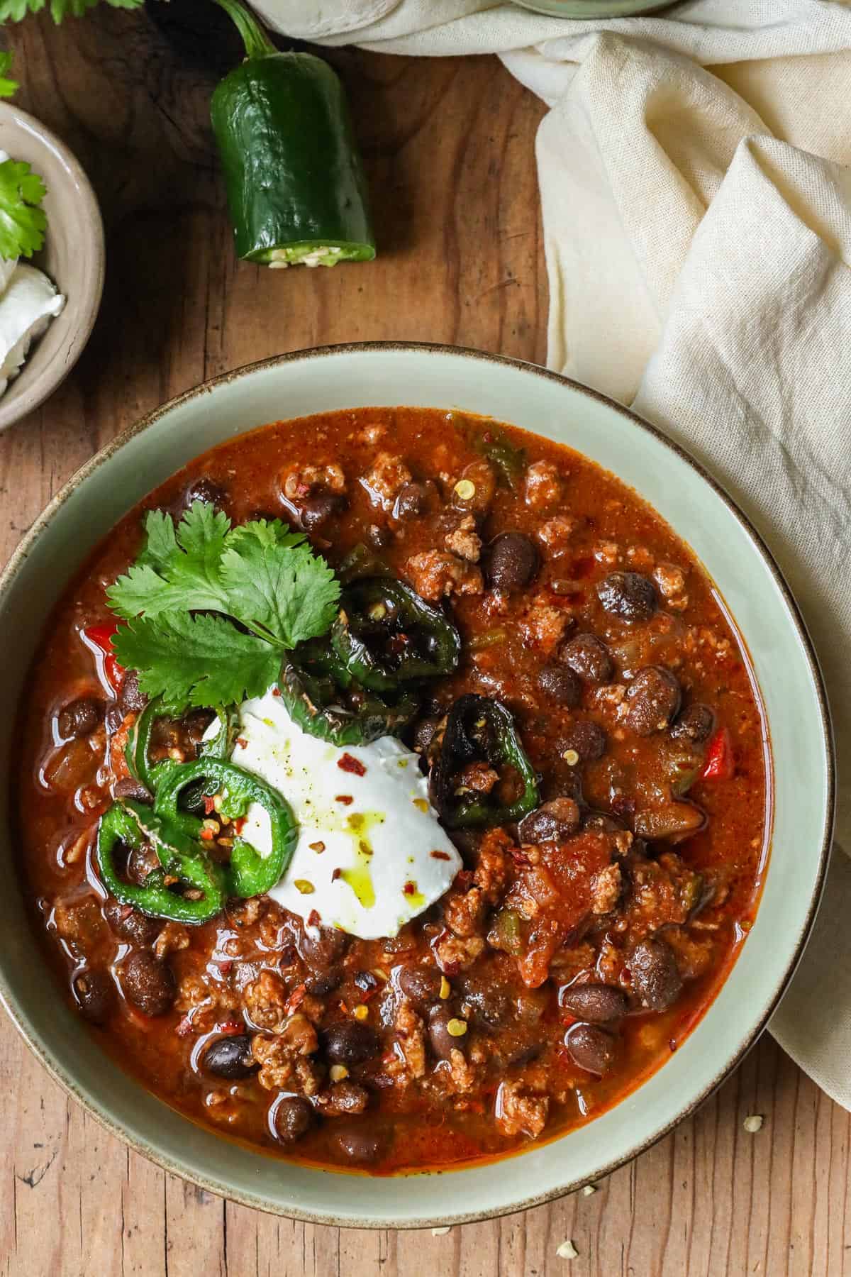 turkey bean chili with cilantro and jalapeño in bowl