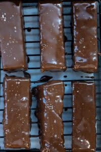 chocolate covered granola bars drying on cooling rack