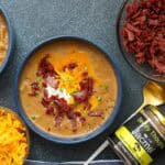 Potato soup topped with bacon, shredded cheese, and sour cream with Jacmel and saint-marc