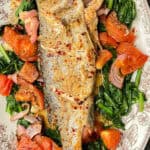 branzino fish on a bed of turnip greens with tomatoes