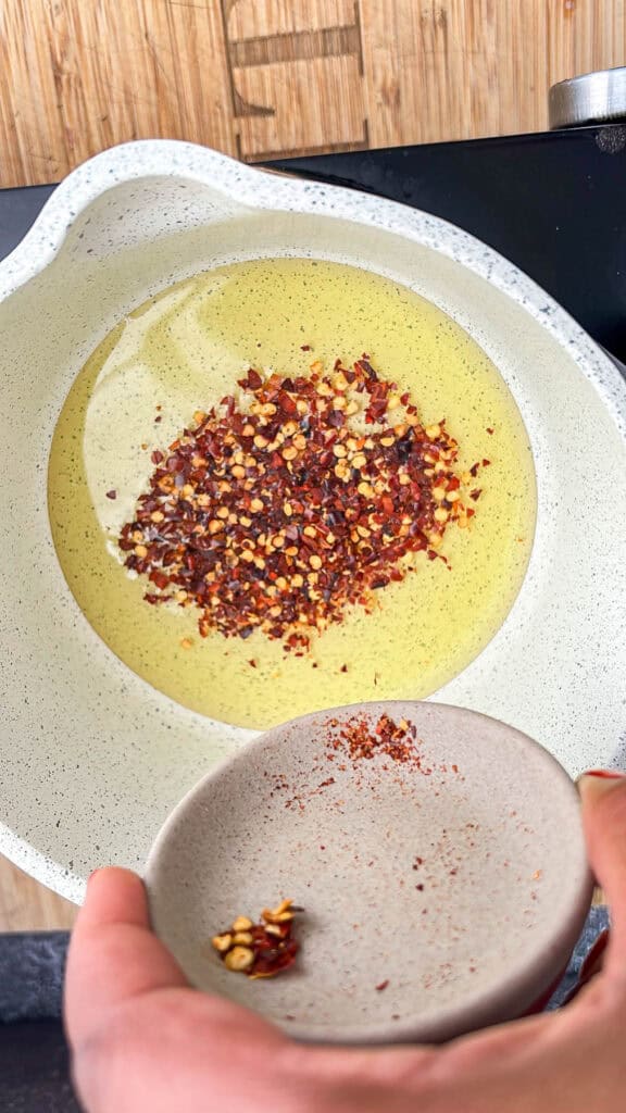 adding pepper flakes to oil