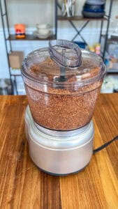 Blender showing almond butter at different stages—crumbly, thick paste, and creamy final texture