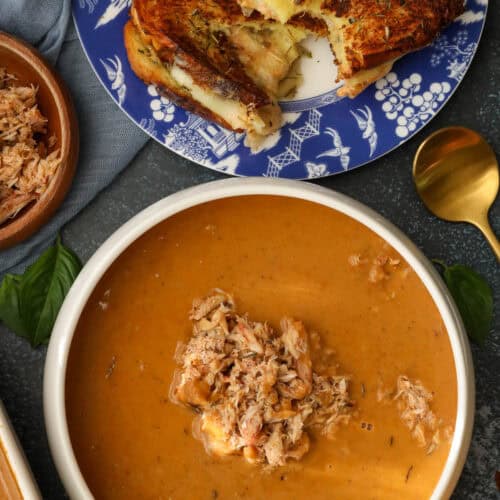Creamy Crab bisque with crab leg in a white bowl