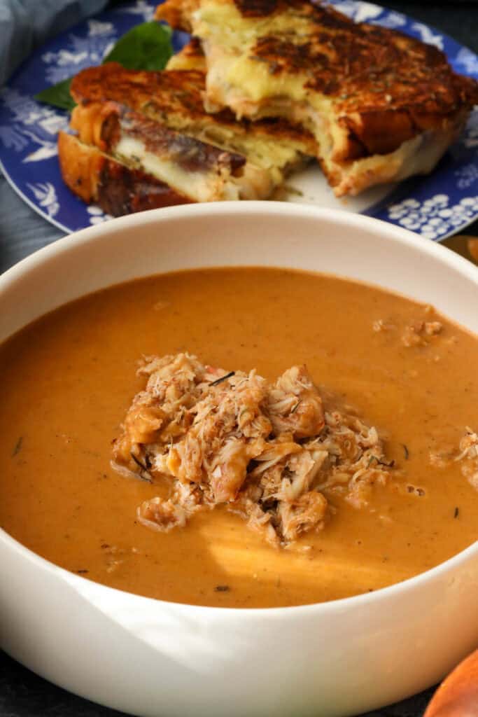 Creamy Crab bisque with crab leg in a white bowl