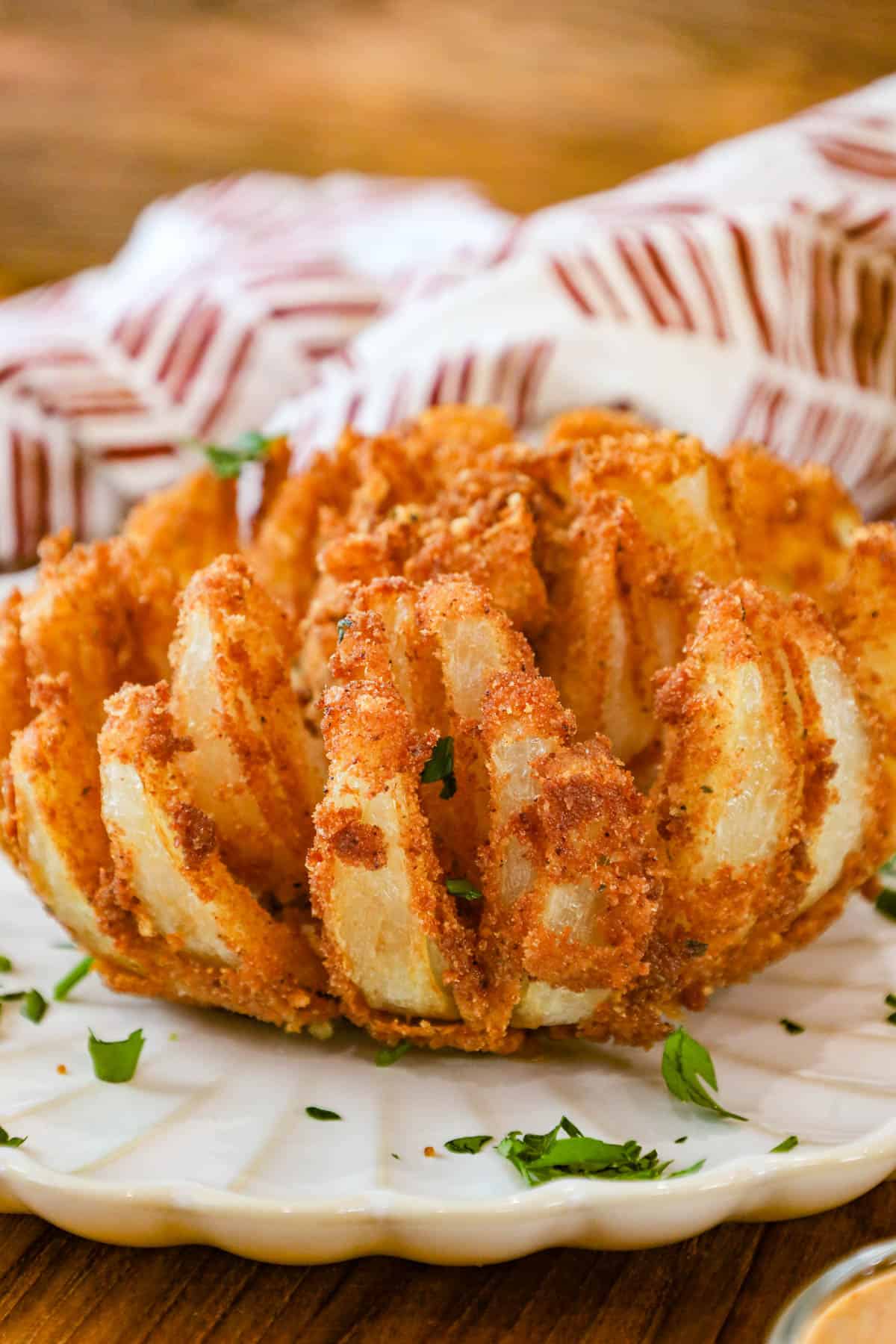 Copycat Bloomin Onion on white plate topped with fresh parsley flakes