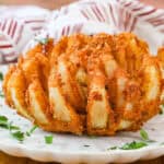 Copycat Bloomin Onion on white plate topped with fresh parsley flakes