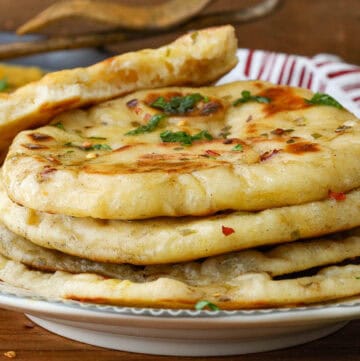 naan bread recipe topped with butter herb and pepper flakes