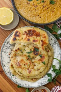 naan bread recipe topped with butter herb and pepper flakes and red lentil curry