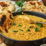 red lentil curry topped with pepper flakes and fresh parsley