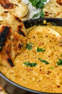 red lentil curry topped with pepper flakes and fresh parsley and parsley