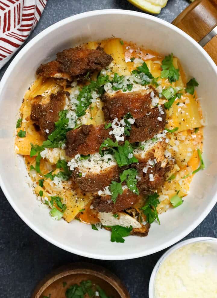 gochujang pasta topped with chicken breast and topped with fresh herbs