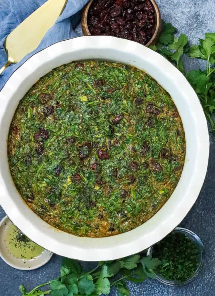 Easy Kuku Sabzi Recipe (Persian Herb Frittata) on board with raisins