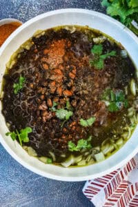 making Mexican black beans in white saucepan