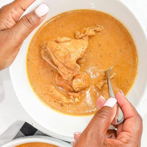 Ghanaian Peanut Butter Soup (Authentic Groundnut Soup Recipe) in white bowl with spoon