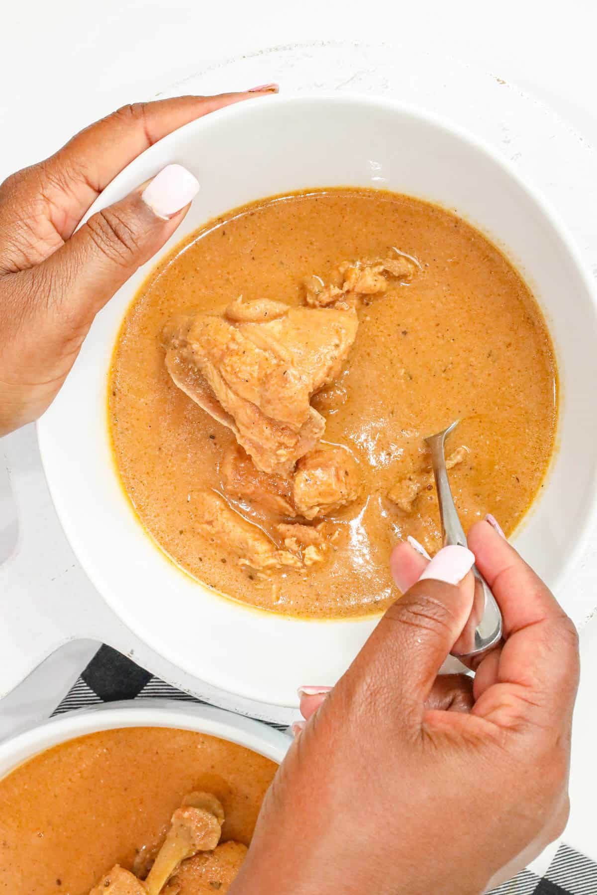 Ghanaian Peanut Butter Soup (Authentic Groundnut Soup Recipe) in white bowl with spoon