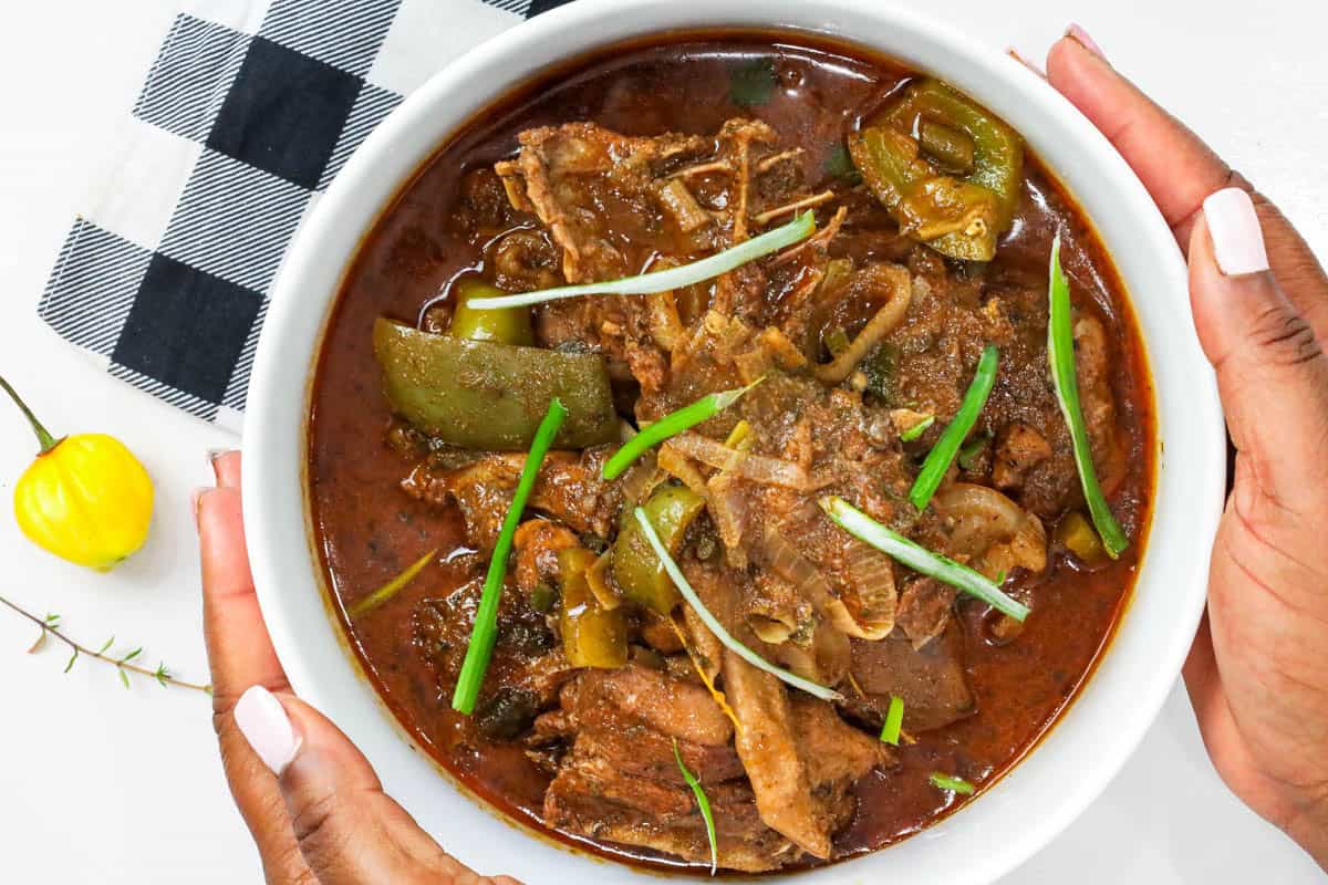 Haitian hard chicken stew in white bowl