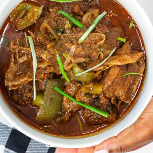Haitian hard chicken stew in white bowl