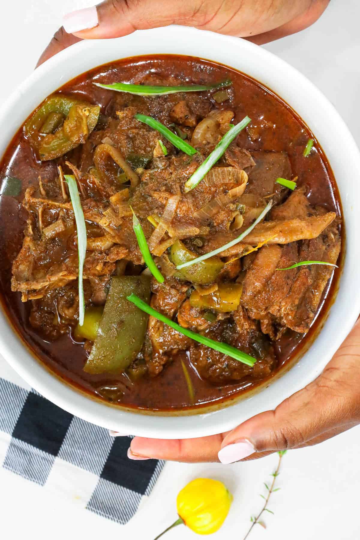 Haitian hard chicken stew in white bowl