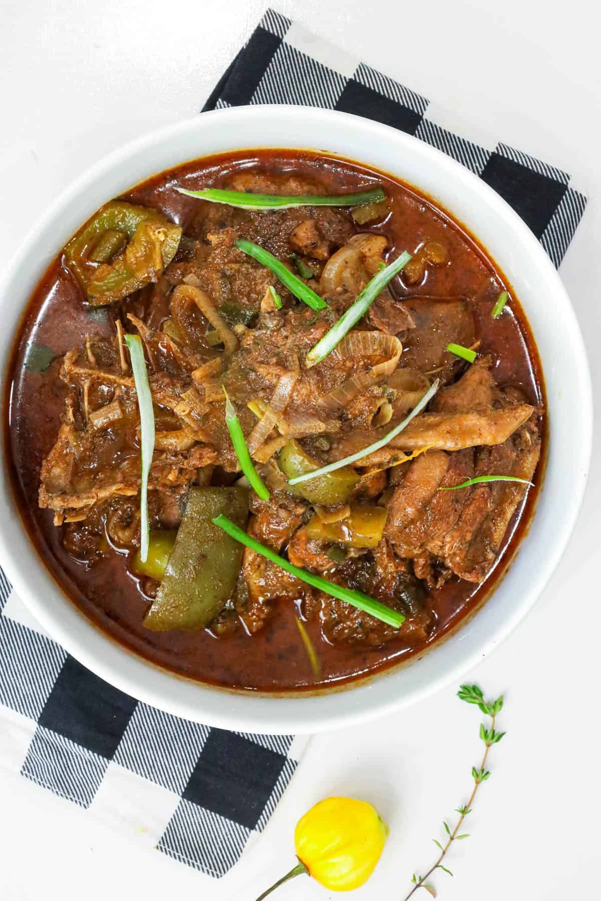 Haitian hard chicken stew in white bowl
