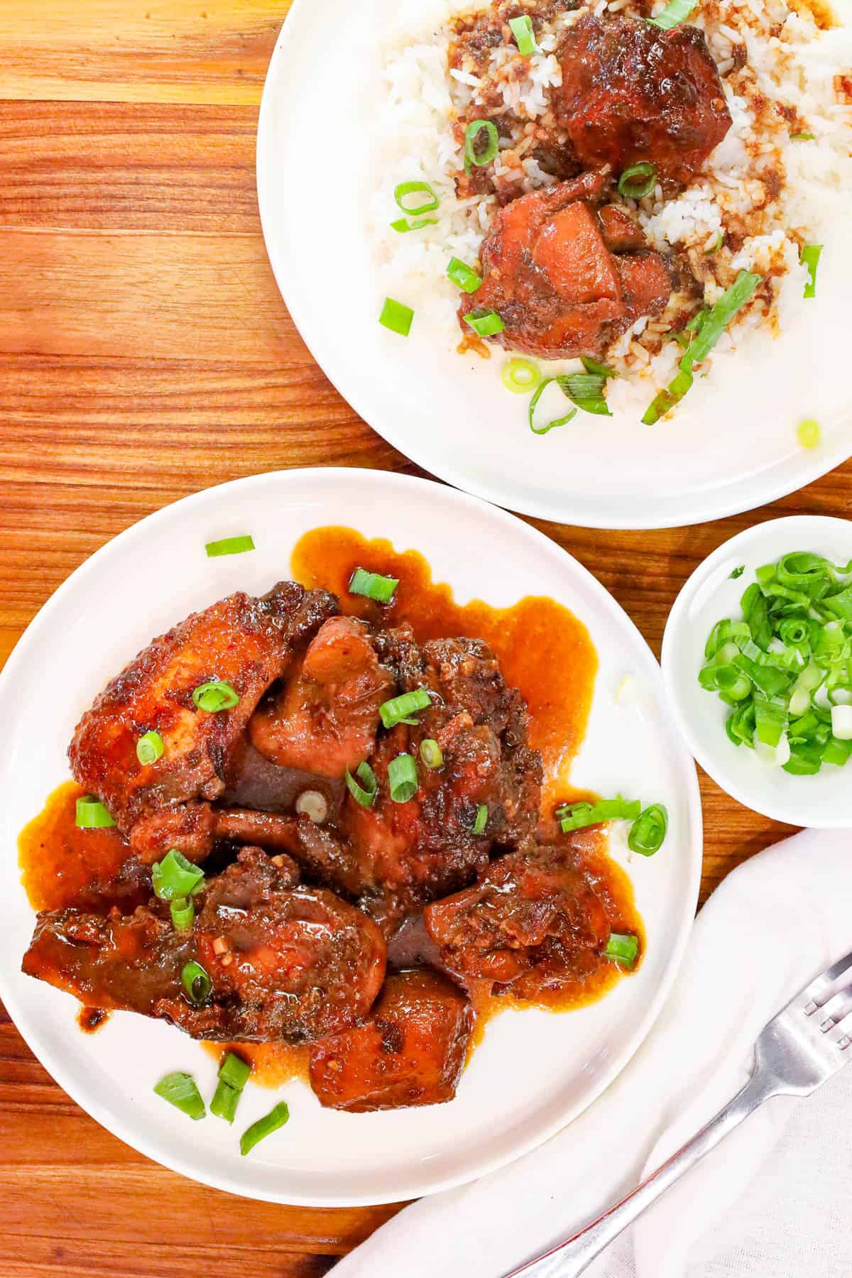 Filipino Chicken Adobo served over steamed white rice with green onions.
