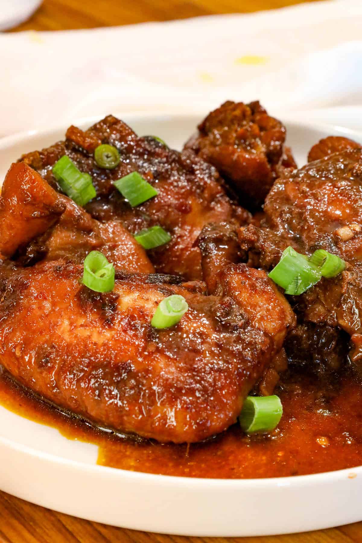 Chicken Adobo garnished with sliced green onions.
