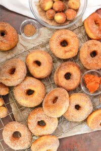 pumpkin donuts on cooling rack dusted with pumpkin sugar