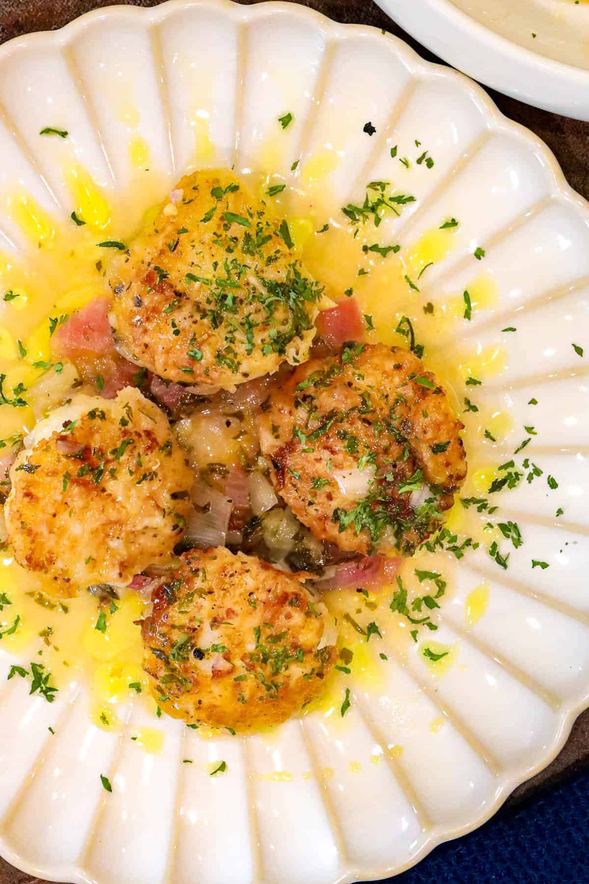 Scallop Provençal in white plate with herbs