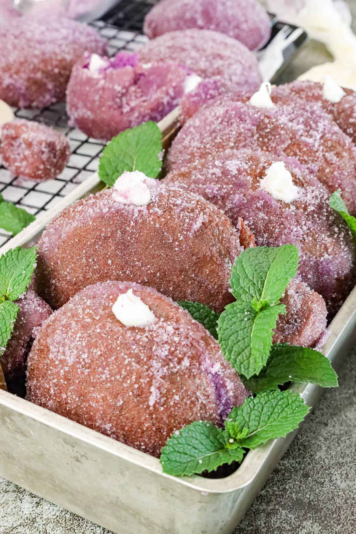 Soft and fluffy Ube donuts filled with vanilla frosting