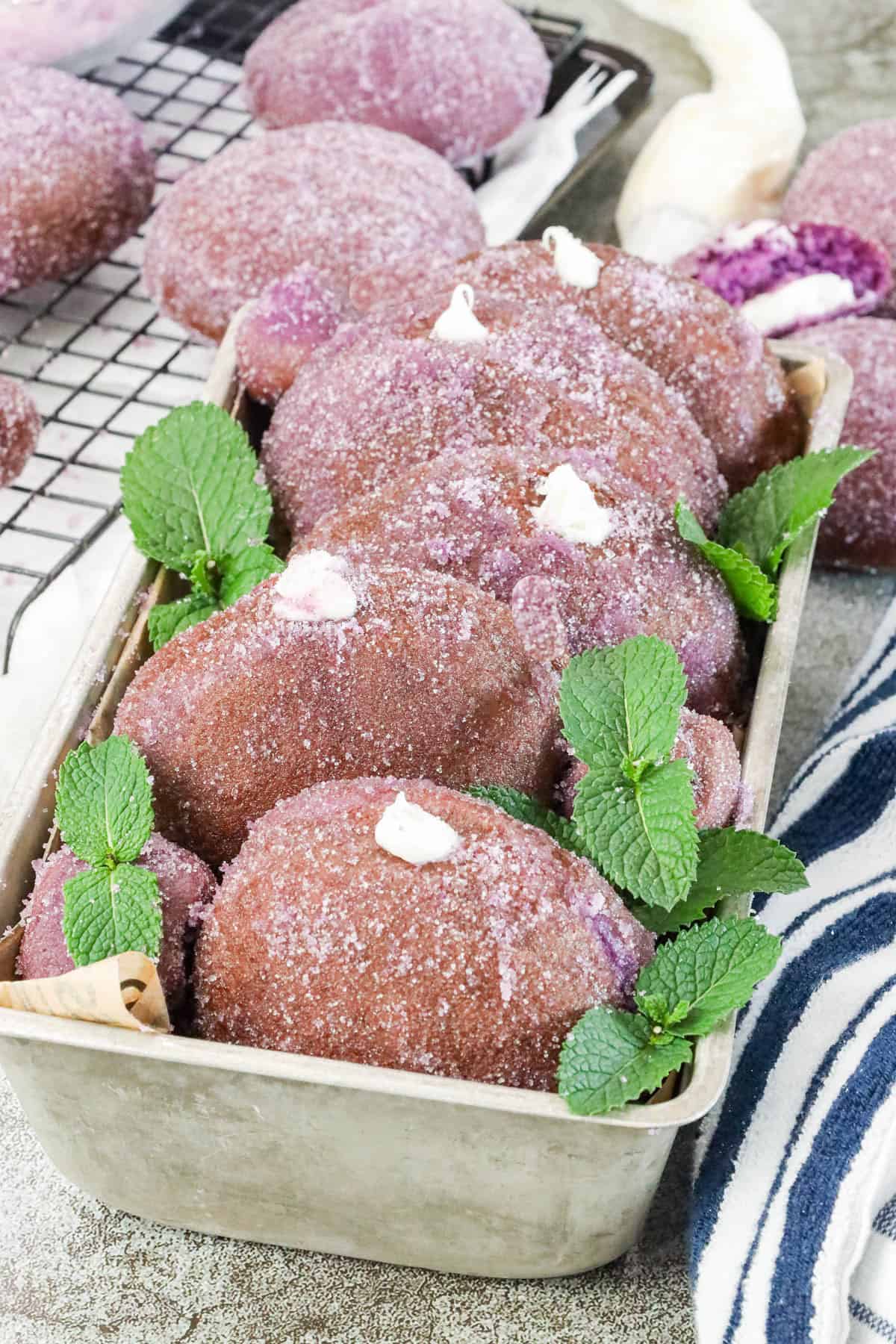 Homemade Yeast Ube Donuts decorated with fresh mint leaves