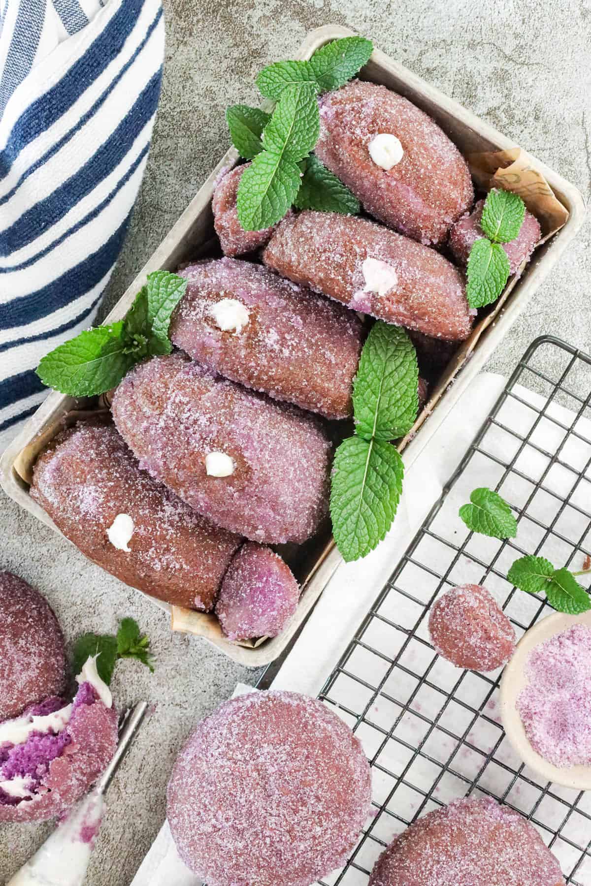 Homemade Yeast Ube Donuts decorated with fresh mint leaves
