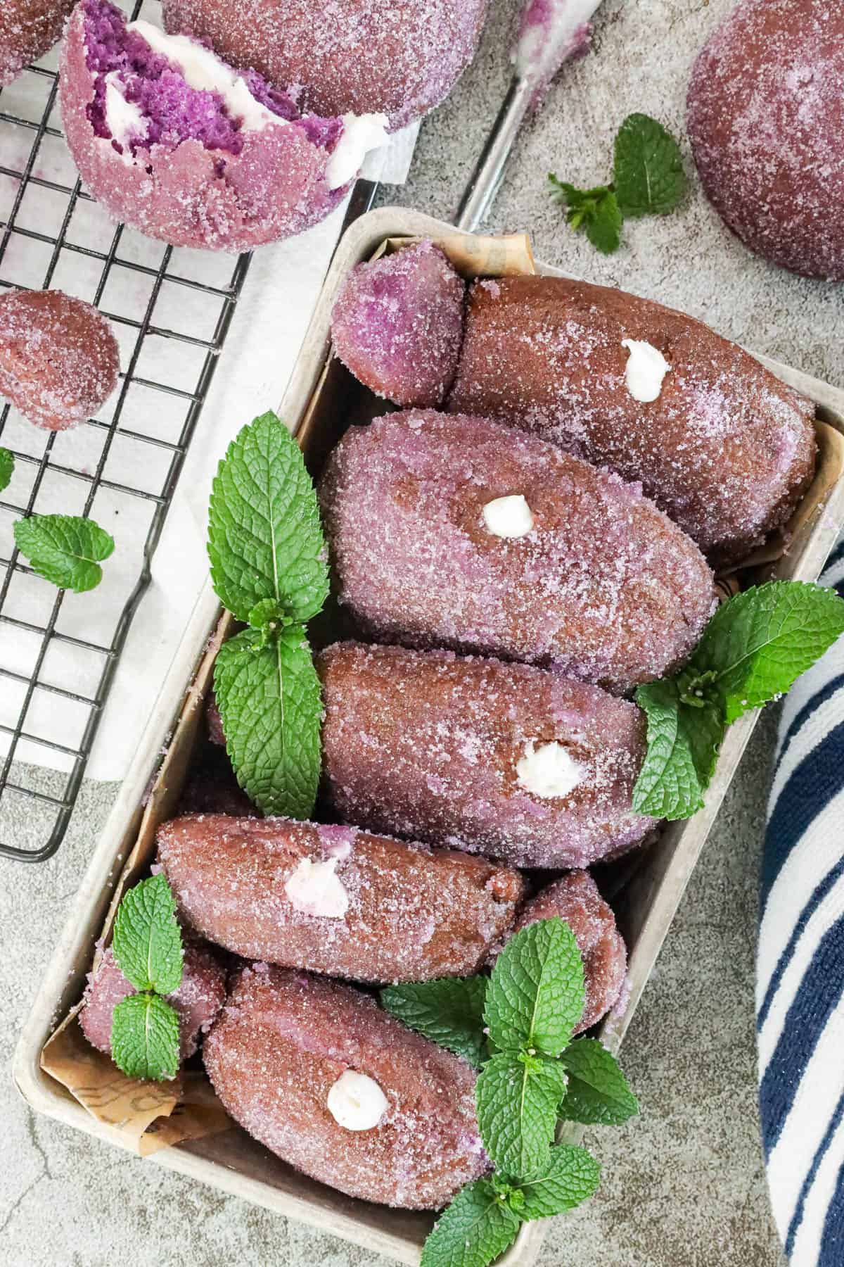 Homemade Yeast Ube Donuts decorated with fresh mint leaves