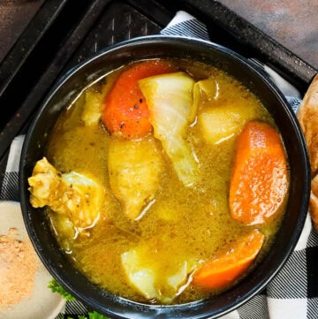 Chicken Soup Joumou (Haitian Chicken Pumpkin Soup) in black bowl