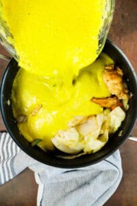 pouring blended pumpkin over veggies and chicken