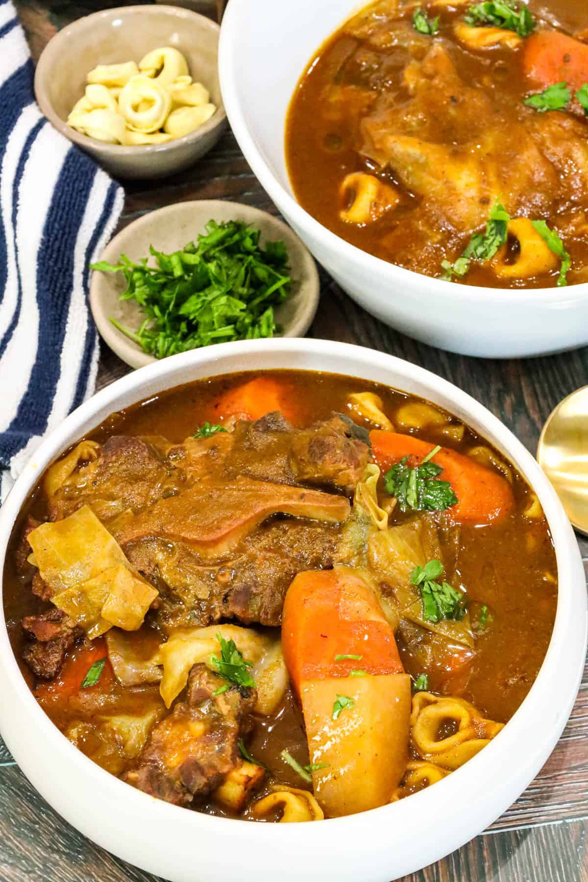 Soup Joumou in white bowl topped with herbs