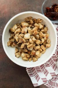 Seasoned chicken breast pieces cooking until golden brown in a skillet with olive oil