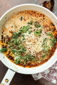 Creamy Marry Me Chicken Pasta sauce with sun-dried tomatoes and seasonings simmering in a skillet