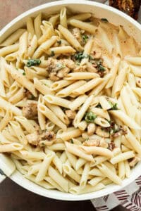 Cooked penne pasta and seasoned chicken tossed together in creamy Parmesan sauce.