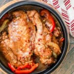 turkey stew in black bowl topped with red pepper flakes